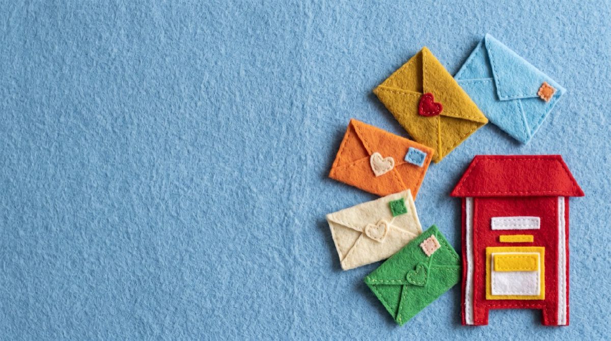 Felt mailbox ringed by colored envelopes